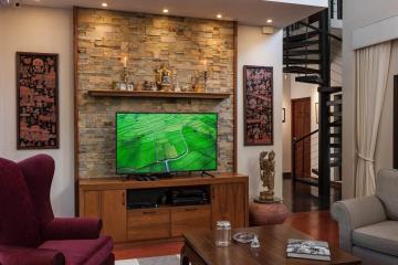 Modern living room with stone wall accent and mounted television