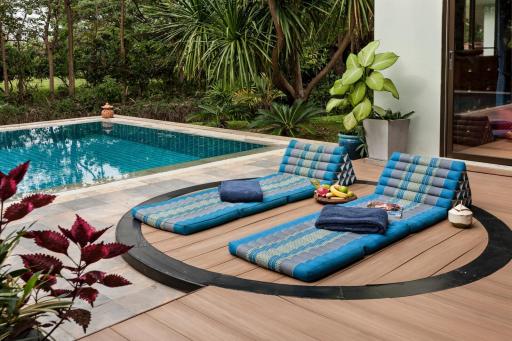 Luxurious poolside lounge area with comfortable seating and tropical plants