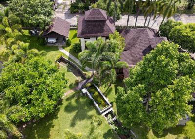 Aerial view of a residential property with lush greenery and multiple structures