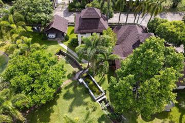 Aerial view of a residential property with lush greenery and multiple structures