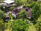 Aerial view of a residential property with lush garden and palm trees