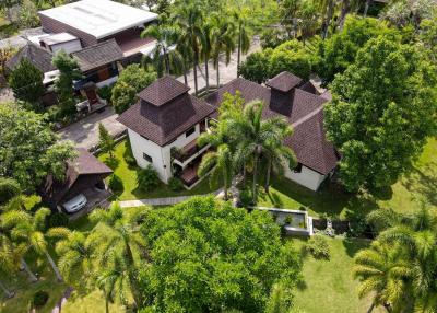 Aerial view of a residential property with lush garden and palm trees