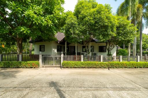 Charming house with a lush green front yard and white picket fence