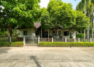 Charming house with a lush green front yard and white picket fence