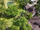 Aerial view of a residential property with lush landscaping and a swimming pool