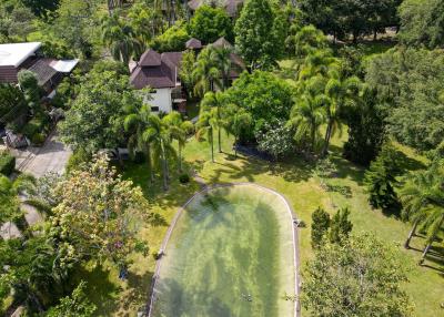 Aerial view of a property with lush greenery and an outdoor pool