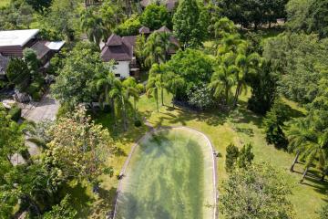Aerial view of a property with lush greenery and an outdoor pool