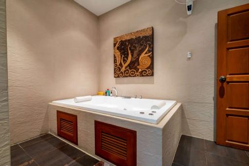 Spacious modern bathroom with a large bathtub and artistic decor