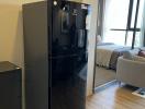 Modern kitchen with stainless steel refrigerator and view into the living room