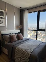 Modern bedroom with large window offering city views