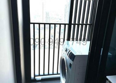 Compact balcony with a washing machine and city view