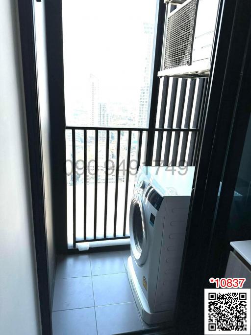 Compact balcony with a washing machine and city view