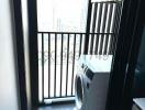 Compact balcony with washing machine and city view