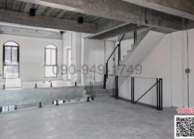 Unfurnished open space interior with staircase and large windows