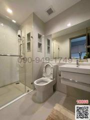 Modern bathroom with a sleek design featuring a walk-in shower, toilet, and basin