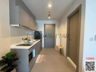 Modern kitchen with compact appliances and wooden flooring