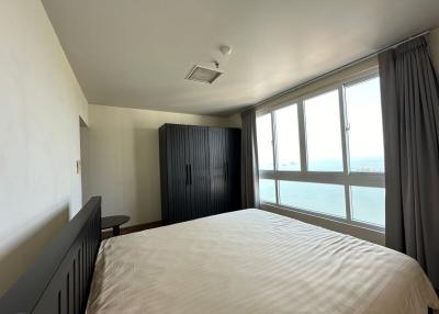 Bright bedroom with large window offering ocean view