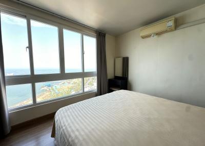 Bright bedroom with a seaside view and a large bed