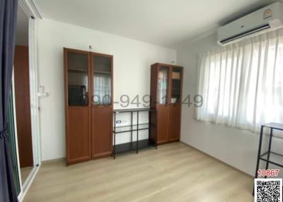 Bright bedroom with air conditioning and wooden furniture