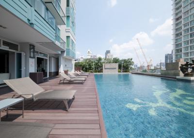 Modern apartment complex with shared swimming pool and lounge chairs