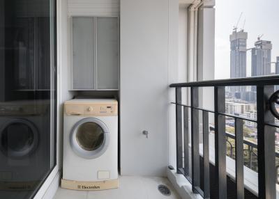 Compact balcony with a washer and a dryer overlooking the city skyline