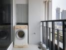 Compact balcony with a washer and a dryer overlooking the city skyline