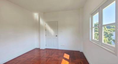 Bright empty bedroom with hardwood floors and a large window