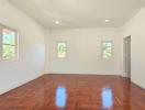 Spacious bedroom with polished hardwood floors and ample natural light