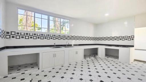 Spacious kitchen with modern black and white tiles and ample natural light