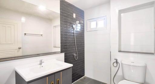 Modern bathroom with black and white tiles, walk-in shower, and vanity