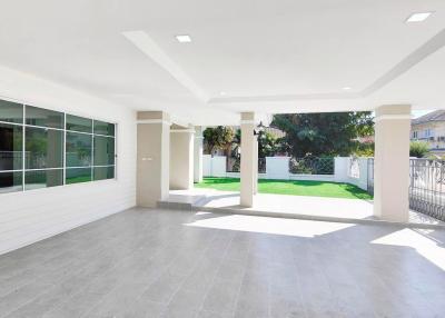 Spacious covered patio with tile flooring and garden view