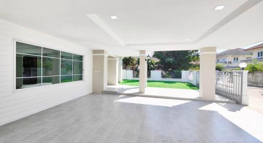 Spacious covered patio with tile flooring and garden view