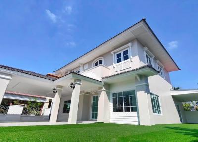 Elegant two-story house with white facade and green lawn