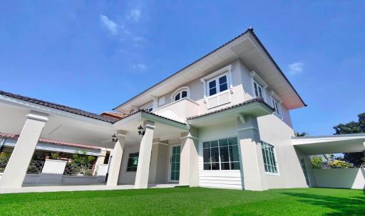 Elegant two-story house with white facade and green lawn