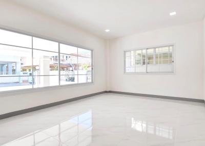 Empty spacious living room with large windows and glossy tiled floor