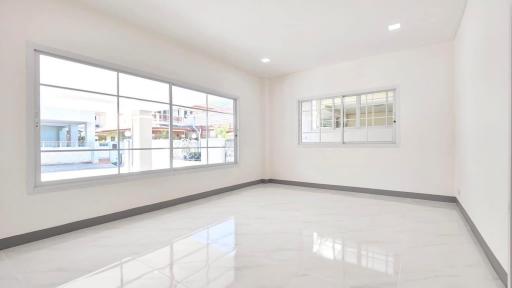 Empty spacious living room with large windows and glossy tiled floor