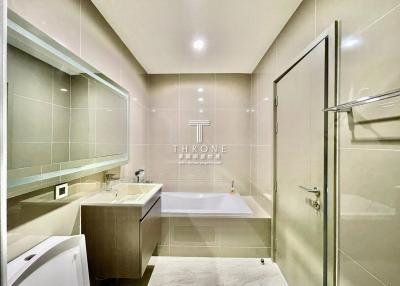 Modern bathroom with bathtub, glass shower enclosure, and vanity