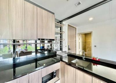 Modern kitchen with stainless steel appliances and a view into the living area
