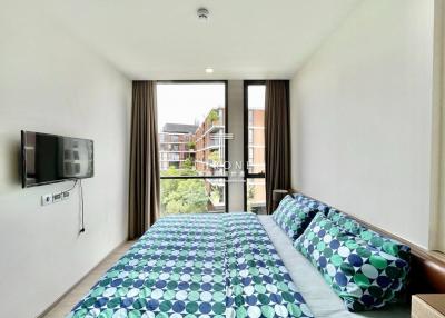 Modern bedroom with large bed and natural light from window