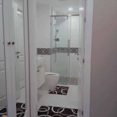 Modern white themed bathroom with glass shower and decorative floor tiles