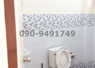 Compact bathroom with white tiles and toilet