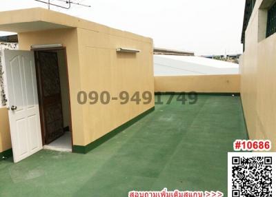 Exterior view of a residential building with a side entrance and green flooring