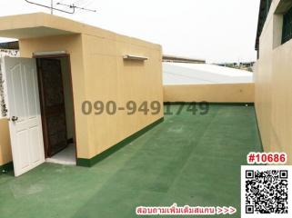 Exterior view of a residential building with a side entrance and green flooring