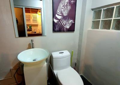 Compact bathroom with modern fixtures and artwork