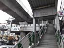 Exterior view of Bang Chak skytrain station with stairs and signage