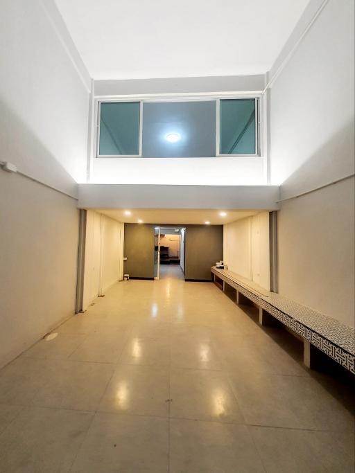 Bright and spacious hallway with high ceiling and tiled flooring