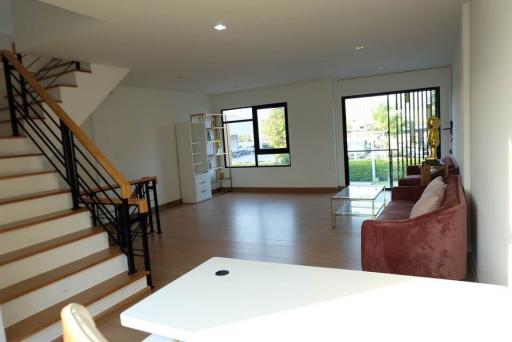 Spacious living room with natural lighting and staircase