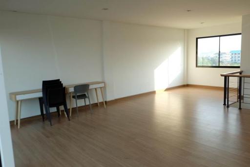 Spacious and well-lit empty living room with hardwood floors