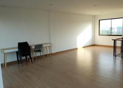 Spacious and well-lit empty living room with hardwood floors