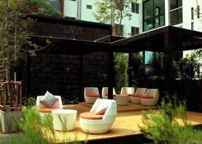 Modern outdoor patio with comfortable seating and lush greenery